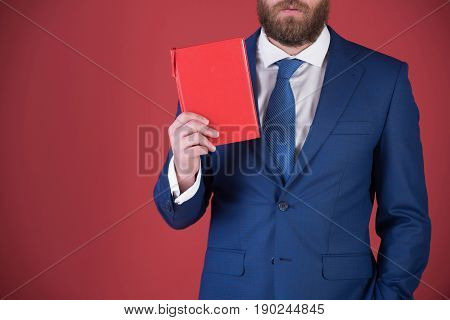 young student with reading book on red background in blue outfit copy space