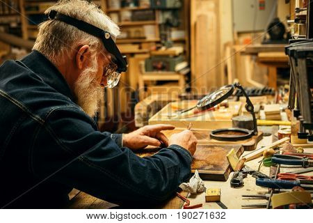 Senior wood carving professional during work