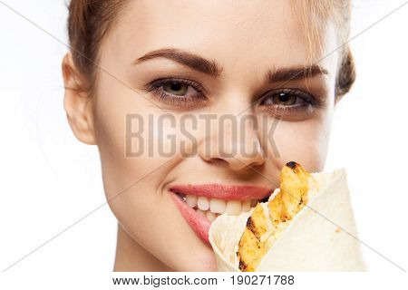 Woman close-up eating a shawarma, woman in the studio eating.