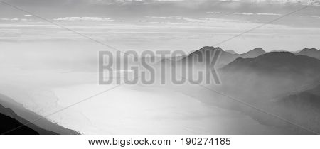 Mountains around the Lago di Garda Italy lake in the fog bw