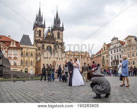 Prague, Czech Republic - March 17, 2017: A wedding couple getting photographed on the Old Town Suqare in the historic city centre