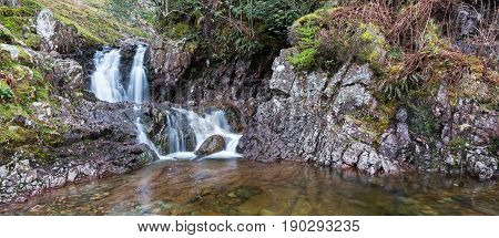English Lake District waterfall on Stickle Ghyll cascading into a clear pool during spring time. Running from Stickle Tarn it is a popular tourist attraction a short drive from Ambleside.