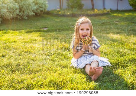 cute cauasian baby girl and big lollipop.