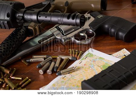 Bullets and a firearm. Bullets are a projectile expelled from the barrel of a firearm over a map, on wooden table.