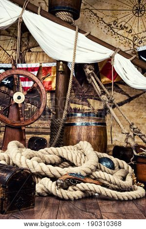 Pirates ship deck with steering wheel and flag.