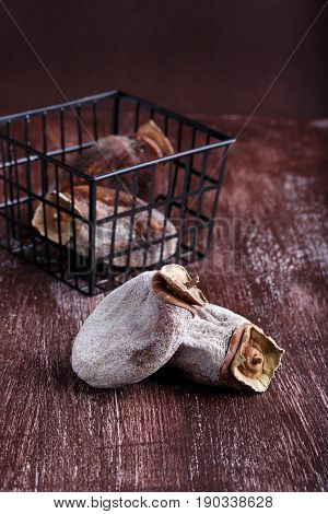 Dried persimmon fruits on dark brown background