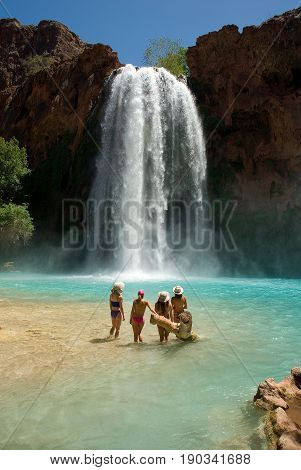 Beautiful group of women standing in front of the world famous Havasu Falls in Arizona