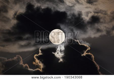 The Moon at it largest also called supermoon with night sky and clouds.