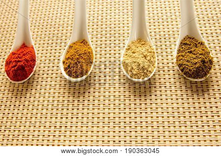 Spices in spoons on the table. Seasoning in powder.