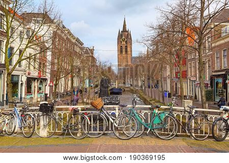 Hague, Netherlands - April 6, 2016: City street, church clock tower and canal view with bicycle in Hague, Holland