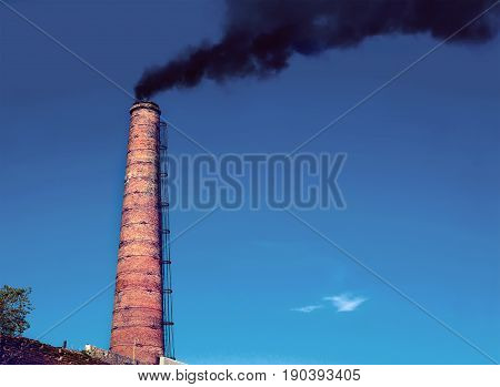 Factory chimney A factory chimney with rising smoke under a blue sky. Pipe from heat power stations