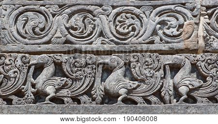 Indian artwork on the Hindu temple walls with friezes mythical swans and designed patterns. 12th centur Hoysaleshwara temple in Halebidu, India
