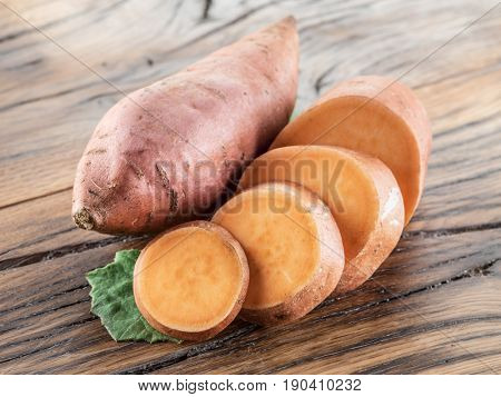 Sweet potatoes on the old wooden table.