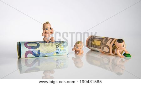 Small baby toys and euro money with white background children figures with euro bank notes
