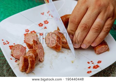 Man Cutting Sausage