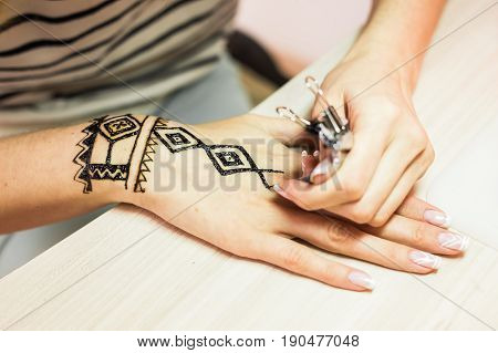 Drawing process of henna menhdi ornament on woman's hand