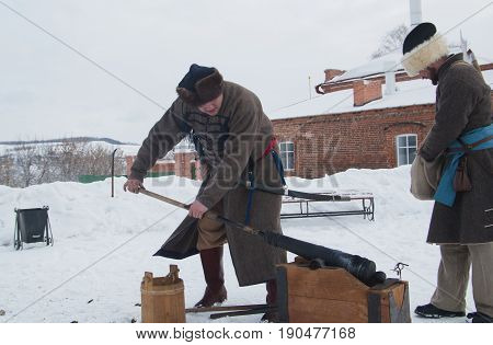 Kazan, Russia - 28 february 2017 - Sviyazhsk Island : Russian ethnic carnival Maslenitsa - A man in an old Russian military uniform charges a cast-iron gun