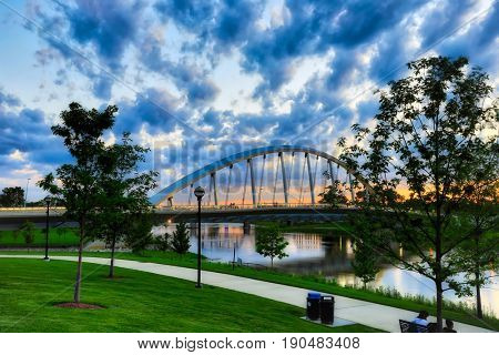 A beautiful sunset in Columbus, Ohio with the Scioto Greenway and the Main Street Bridge in the foreground.