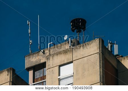 Civil defense siren on top of apartment building also known as air raid siren provides emergency warning of approaching danger such as tornadoes
