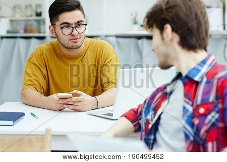 Attentive student listening to his groupmate during conversation