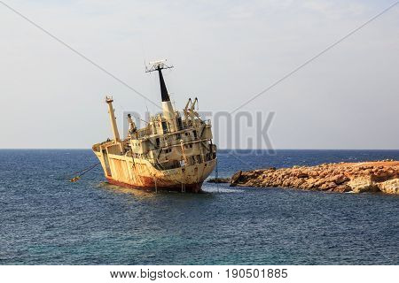 Seascape: boat EDRO III shipwrecked near the rocky shore at the sunset. Mediterranean near Paphos. Cyprus