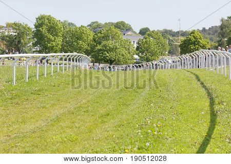 STOCKHOLM SWEDEN - JUNE 06 2017: The gallop horse race hippodrome trees in the background at Nationaldags Galoppen at Gardet. June 6 2017 in Stockholm Sweden