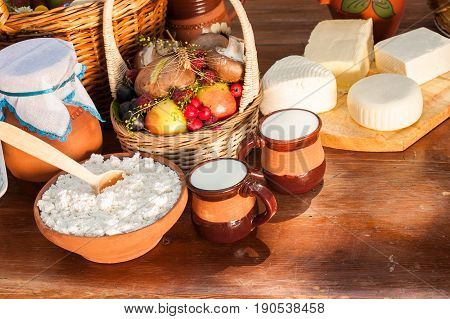 Dairy farm products on wooden table. Cheese and milk on the table in an earthenware dish. Rustic, organic food, farm products concept. Food background.