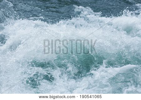 splashes of blue sea waves close up. Churning blue water in the ocean shows lots of turbulence and splash. freshness, wave, surfing concept. elements of water.