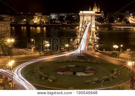 Long-exposure night shot of a square a bridge and their traffic