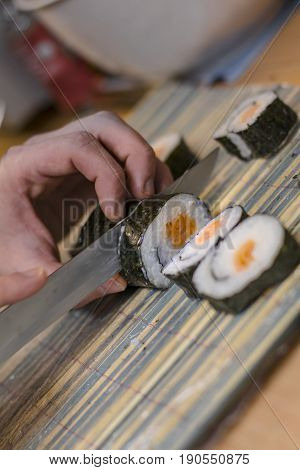 Maki Sushi With Smoked Salmon Being Cut