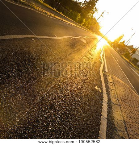 Sunrise above asphalt road with gold lights