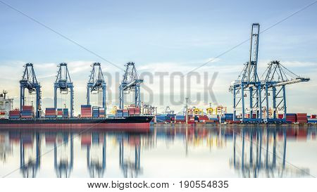 International Container Cargo ship with working crane bridge in shipyard background logistic import export background and transport industry.