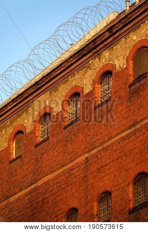 The outside view of an old and abandoned jail in Berlin during sunset