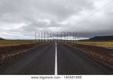 Iceland Asphalt Road Leading Straight To The Horizon. Empty Straight Road Line In Rural Icelandic La