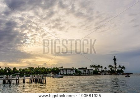 Florida lighthouse at sunrise with passing boats