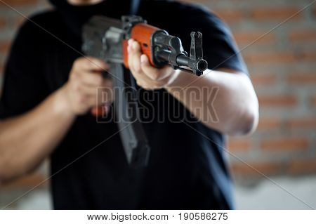 Portrait of terrorist holding assalt riffle close up.