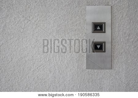 The modern lift button panel on stone tite wall close up background.
