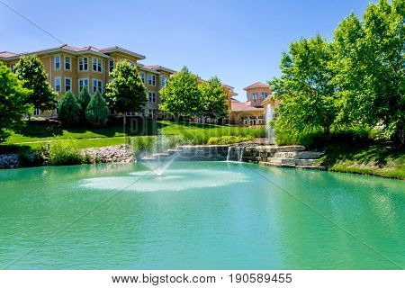 Beautiful waterfall fountian in front of italian style building near park