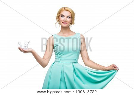 Beautiful young adult blond woman in mint dress  with princess crown. Making a wish. Isolated on white background. Copy space.