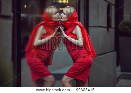 Woman admires herself in the reflection of the shop window she is in love with herself.