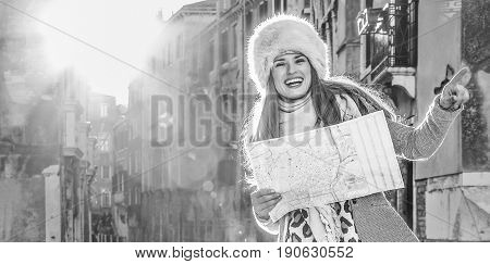 Woman In Venice, Italy In Winter Holding Map And Pointing