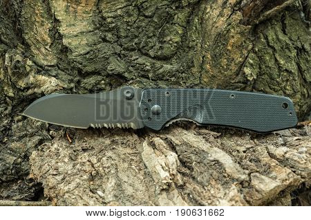 Black Knife. Pocket Knife. A Knife With A Serration Blade.
