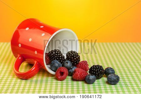 Cup with scuttered berries on the table