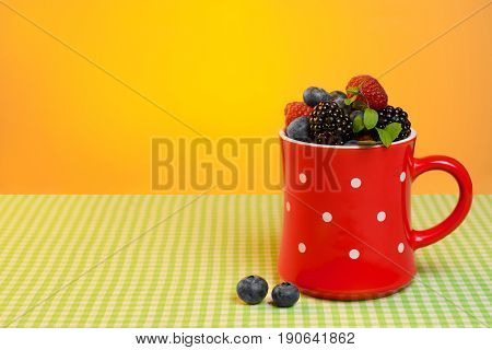 Cup with scuttered berries on the table