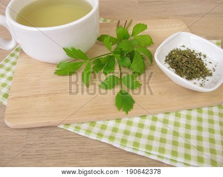 Cup of herbal tea with lovage and lovage leaves