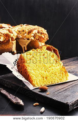 Slice of Colomba - italian easter dove cake on old rustic black wooden board. Selective focus free .