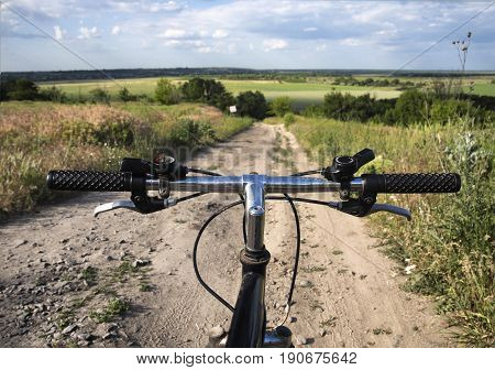 First person view on a sport bicycle before descending into the landscape valley