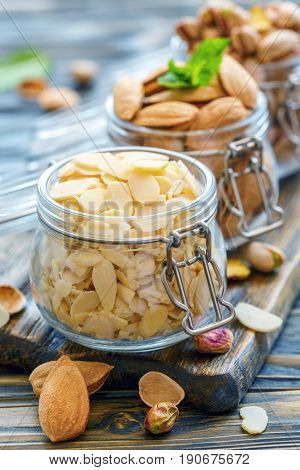Almond Flakes And Inshell Almonds In Glass Jars.