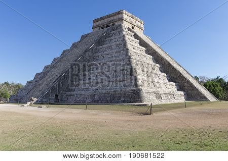 Famous El Castillo Temple of Kukulkan at Maya ruins of Chichen Itza with shadow of serpent along staircase under clear blue sky