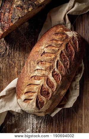 Rustic sourdough bread on wooden table, top view